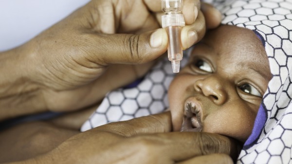 A baby in Africa is given the oral vaccination against polio.