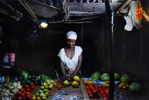Solar lamp Little Sun illuminates the market stand of a woman in Africa