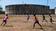 Fußball spielende Kinder vor Kraftwerk am Lake Managua