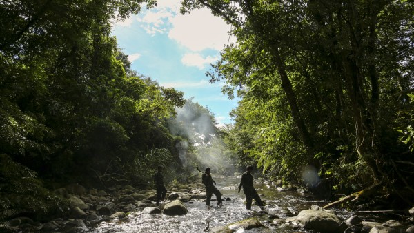 Ranger waten durch einen Fluss im Annamitengebirge.
