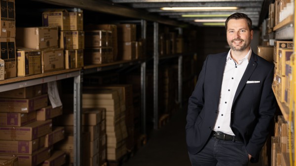 weLOG founder Manuel Rupp stands leaning against a storage shelf 