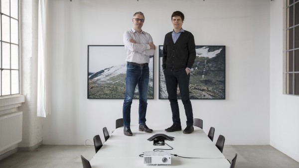 Rhebo-Gründer Frank Stummer und Klaus Mochalski stehen auf einem Konferenztisch