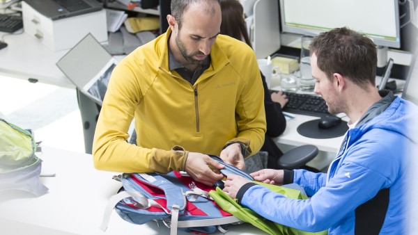 Staff discuss colour variations of a rucksack at Vaude