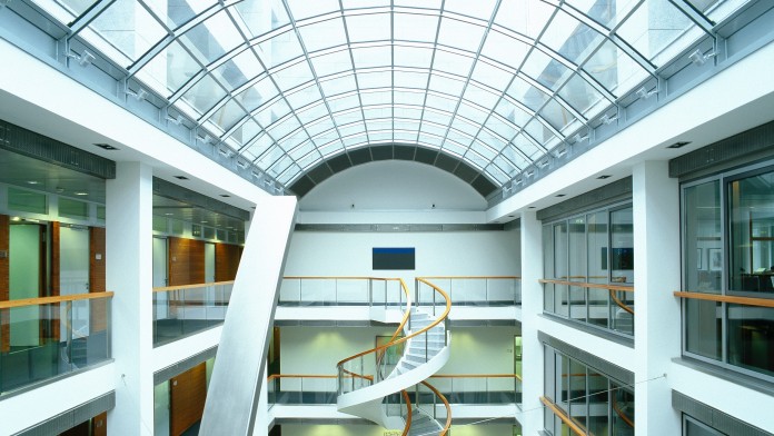 Innenansicht eines Bürogebäudes mit Treppe und gläsernem Dach