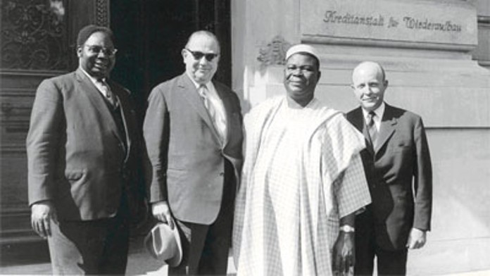 Four people in front of the KfW building in the 1950s