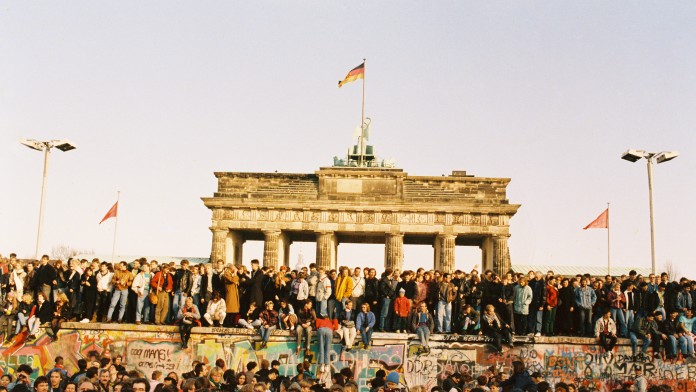 Jubelnde Menschen vor dem Brandenburger Tor nach dem Mauerfall 