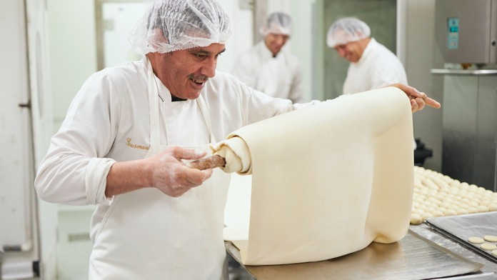 Mitarbeiter der Bäckerei Gourmandise beim Teig rollen