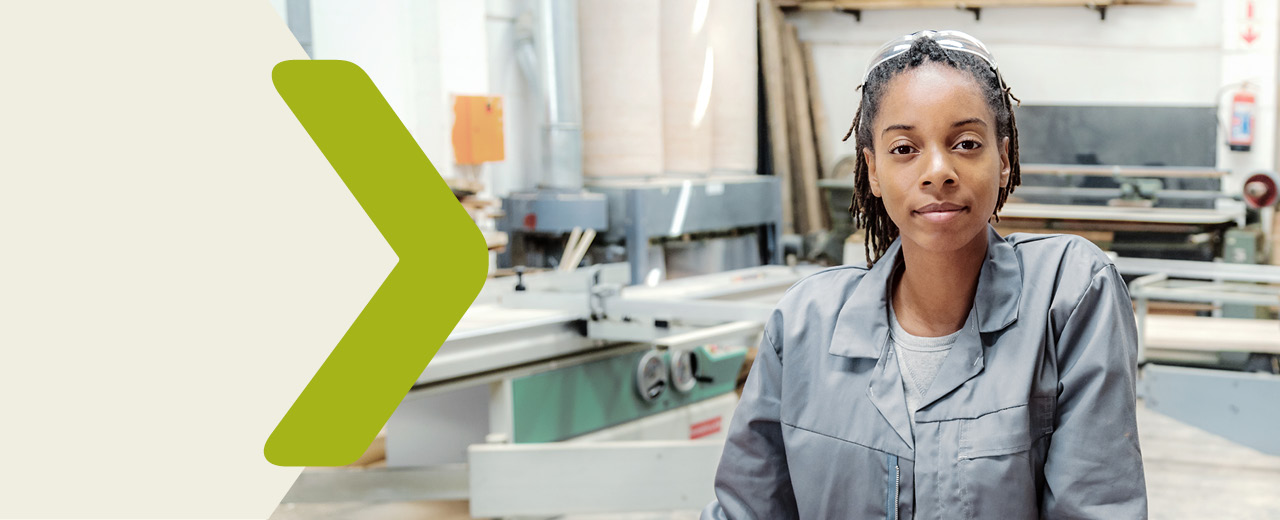 Portrait of a young woman in a carpenter's workshop