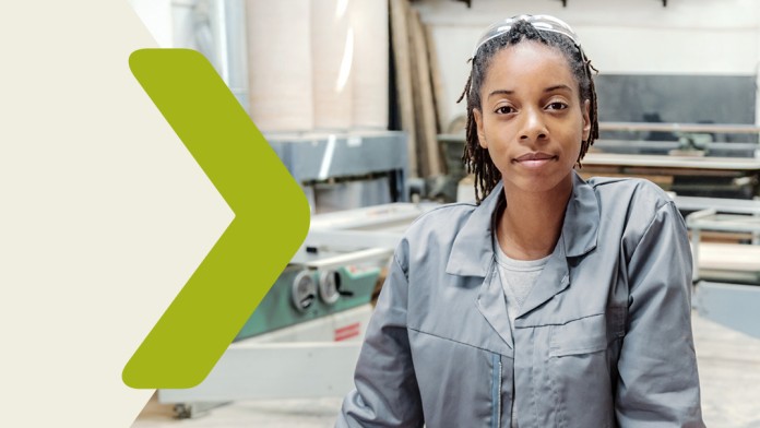 Portrait of a young woman in a carpenter's workshop