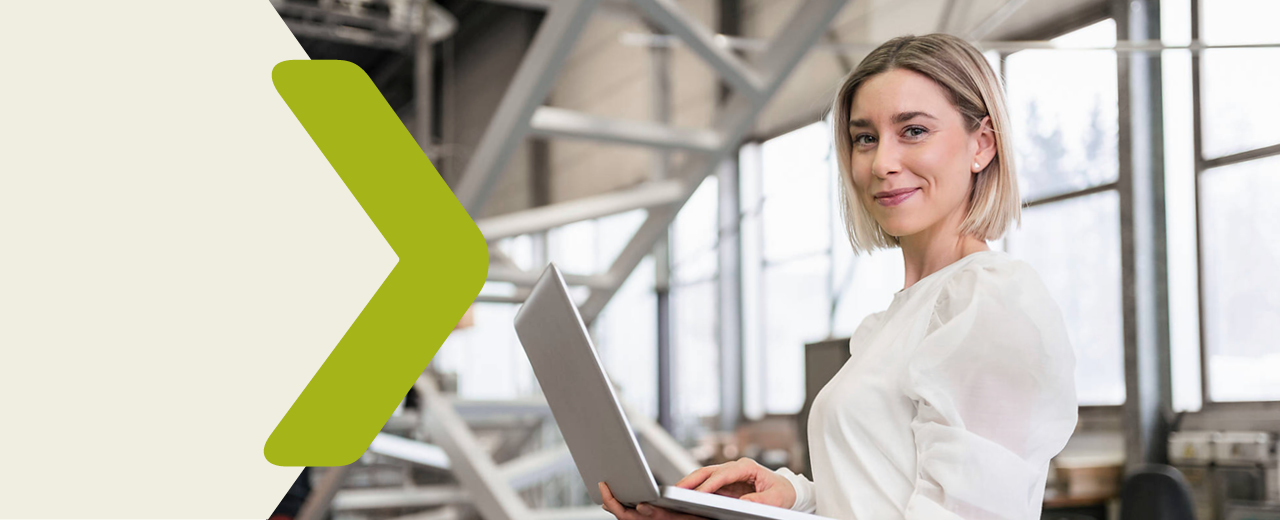 Portrait of a woman with a laptop in a production facility