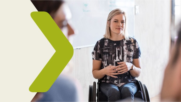 A young woman in a wheelchair and two other people in an office