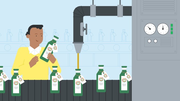 Worker in a factory filling oil into bottles on an assembly line.