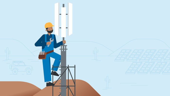 A worker repairs a mobile phone mast in the desert