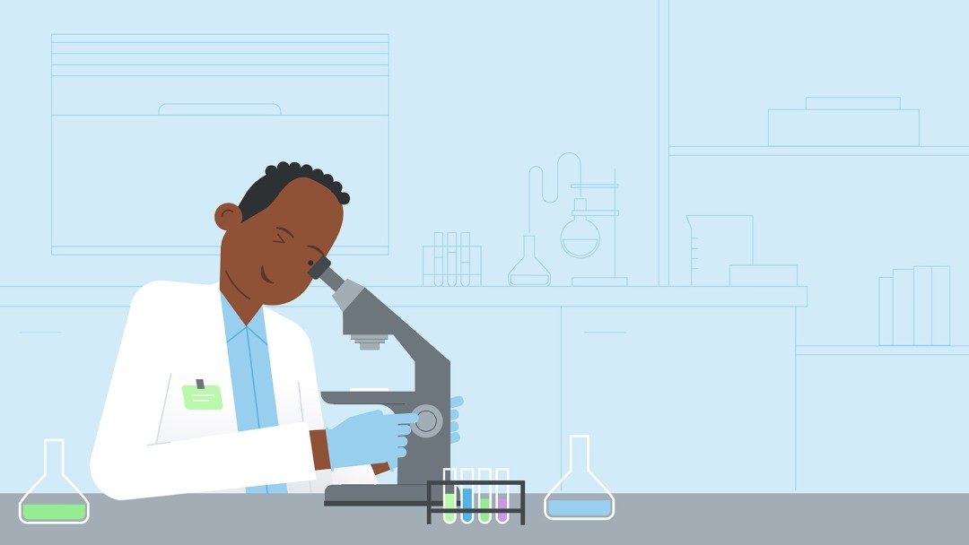 A person in a white coat looks into a microscope