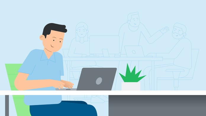 A person is sitting at a table on a laptop