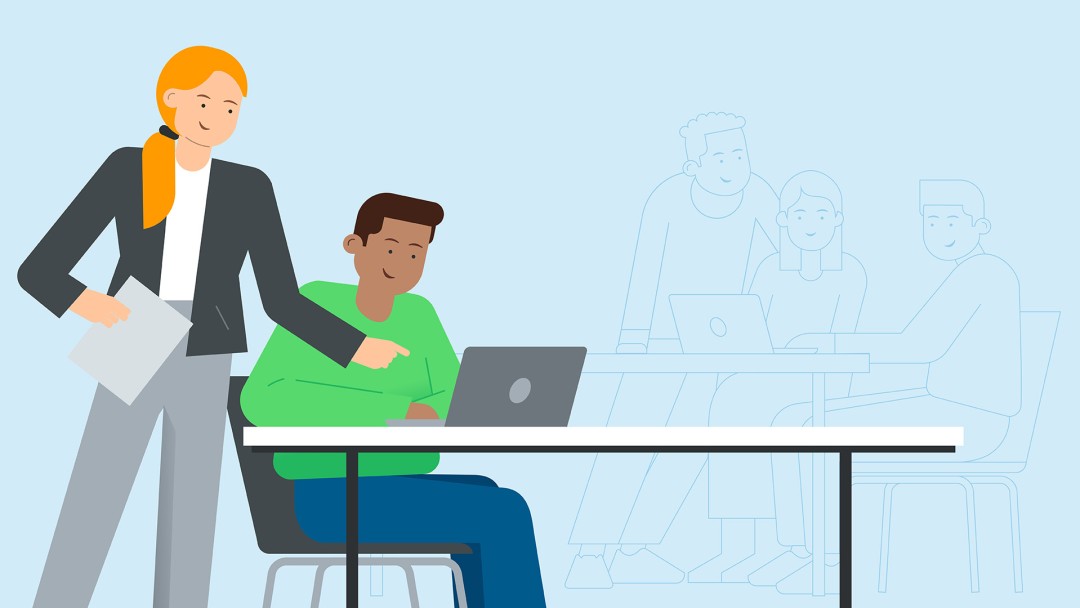 Two people in the foreground working together on a laptop. In the background, other people working on their laptops.