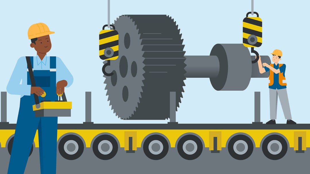 A worker stands in a hall in front of a huge gear wheel for a steelworks.