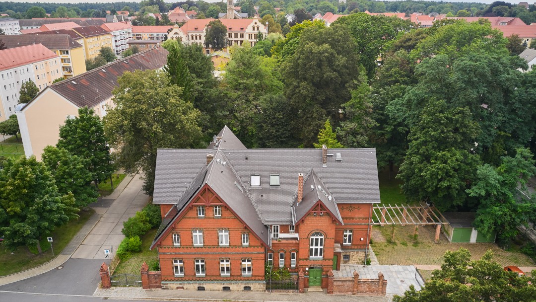 Luftaufnahme eines großen, roten Hauses mit einem schwarzen Dach