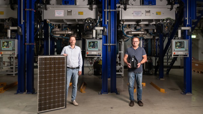 Wolfram Palitzsch und Dr. Ingo Röver (v.l.), Gründer von LuxChemtech posieren mit einem Solarpanel und einem Siliziumblock
