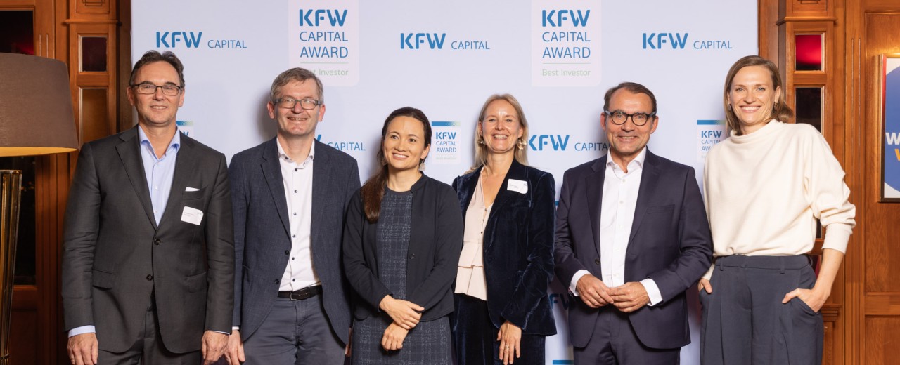 Foto der Gewinnerinnen des KfW Capital Award 2025 vor der Logo-Wand