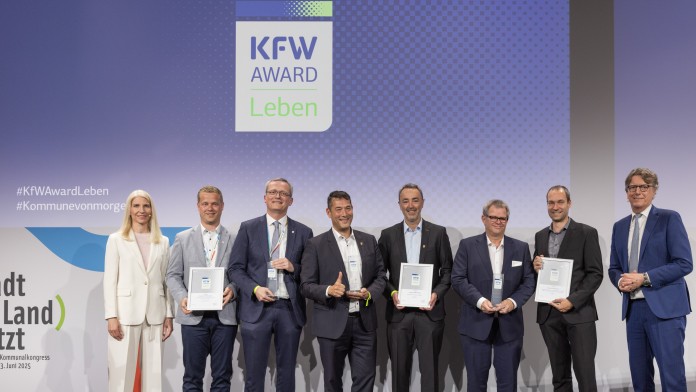 Preisverleihung des KfW Award Leben in der Kategorie „Energie- und Wärmewende". Gruppenfoto der Gewinner auf der Bühne.