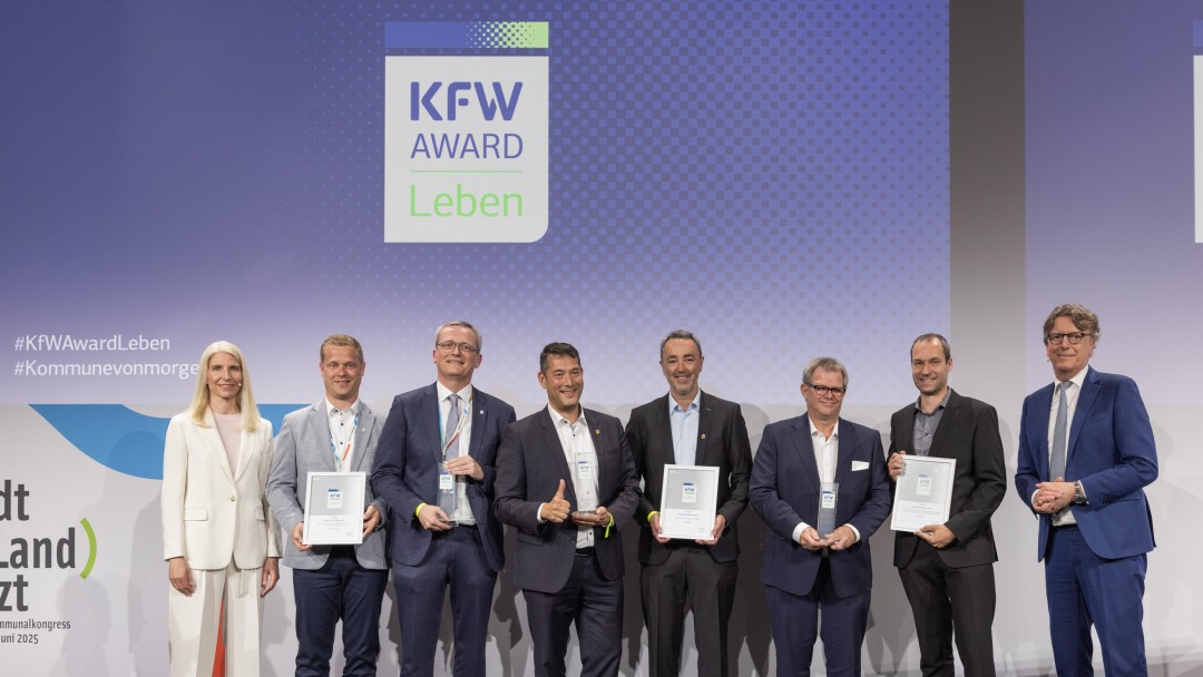 Preisverleihung des KfW Award Leben in der Kategorie „Energie- und Wärmewende". Gruppenfoto der Gewinner auf der Bühne.