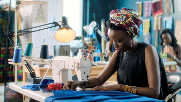 Afrikanische Arbeiterin an Nähmaschine