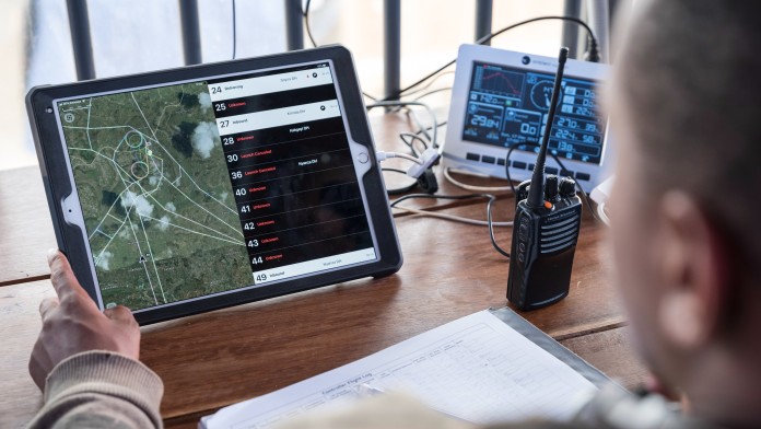 Mitarbeiter berechnet die Route einer Drohne auf einem Tablet