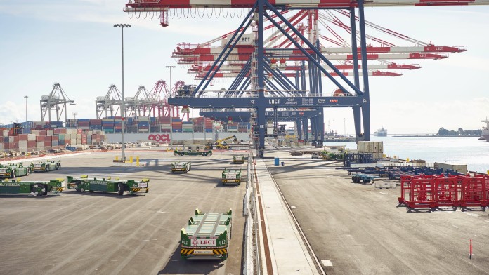 Containerhafen mit Lastkränen und automatischen führerlosen Containertransportfahrzeugen