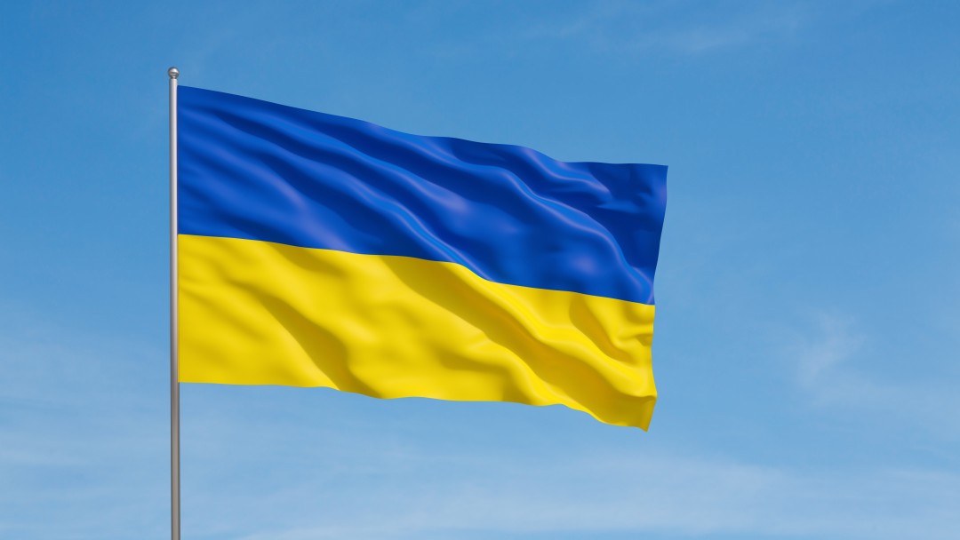 Die wehende Flagge der Ukraine mit dem Himmel im Hintergrund.