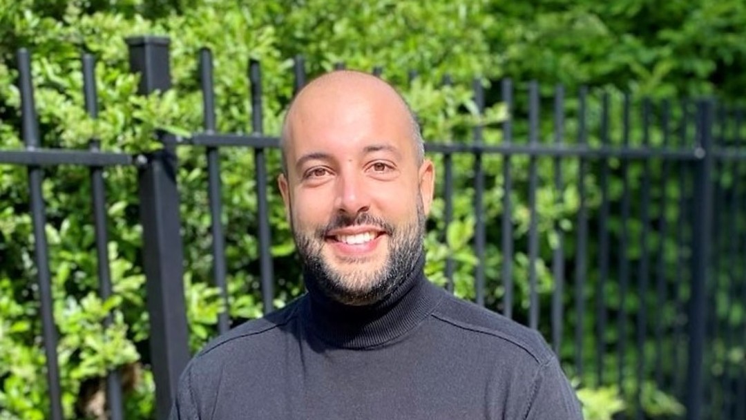 Tarik El Bouyahyani, Mitarbeiter aus der Abteilung Beyond Banking. Er trägt einen schwarzen Rollkragenpullover und schaut freundlich in die Kamera.