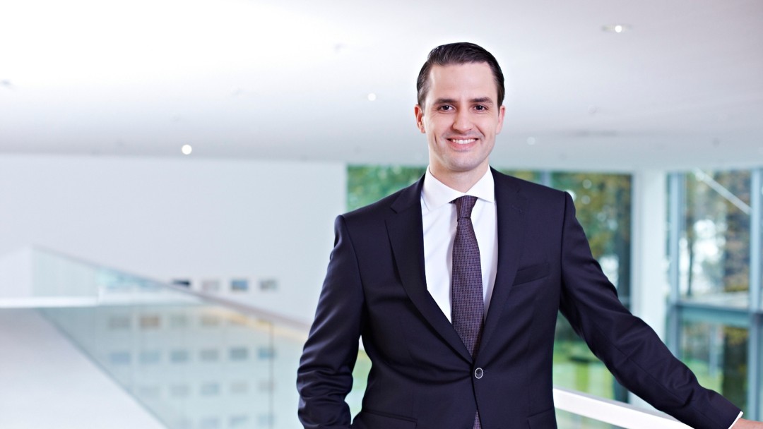 Dr. Seitz steht in der ersten Etage des Foyers 