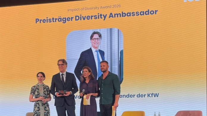 Es stehen vier Personen auf der Bühne, davon zwei Damen und zwei Herren. Der Vorstand der KfW hält den Award 