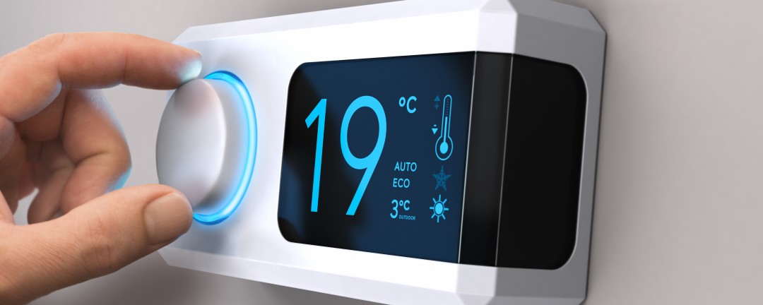 Ein Raumthermostat wird heruntergedreht.