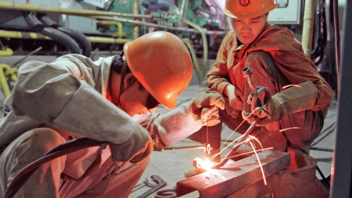 Arbeiter schweißen Metallteile zusammen