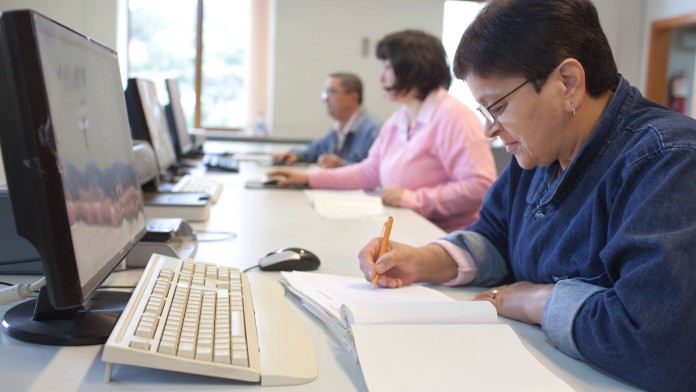 Ältere Dame bei einer Fortbildung am PC