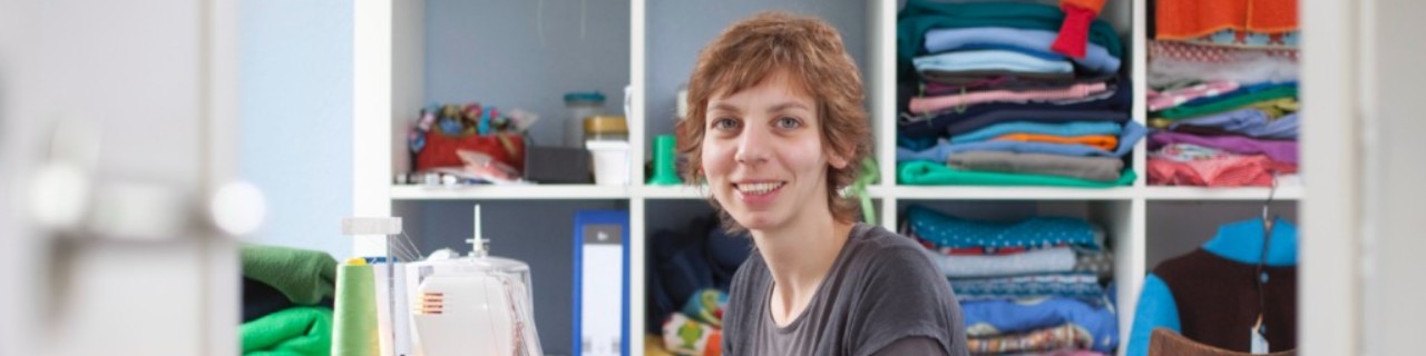 Eine Frau sitzt an der der Nähmaschine