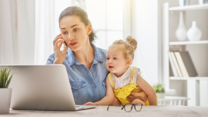 Mutter mit Kind vor dem Laptop im Homeoffice