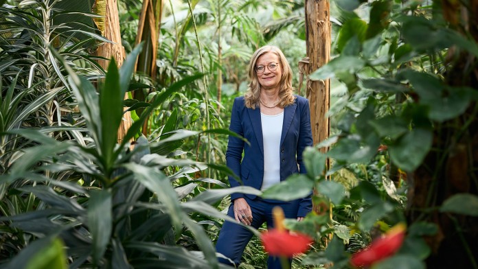 Christiane Laibach steht in einem exotischen Palmengarten.