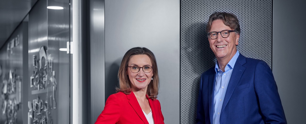 Eine Frau und ein Mann stehen vor einer beleuchteten Wand