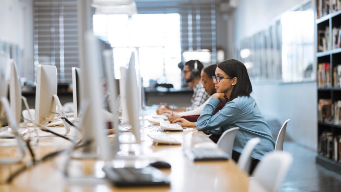 Aufnahme einer Gruppe von Universitätsstudenten bei der Arbeit an Computern in der Bibliothek