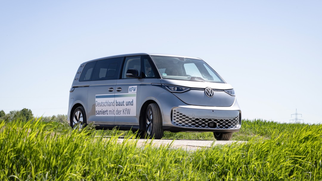 Ein VW Bus mit KfW Branding an einem Feldrand