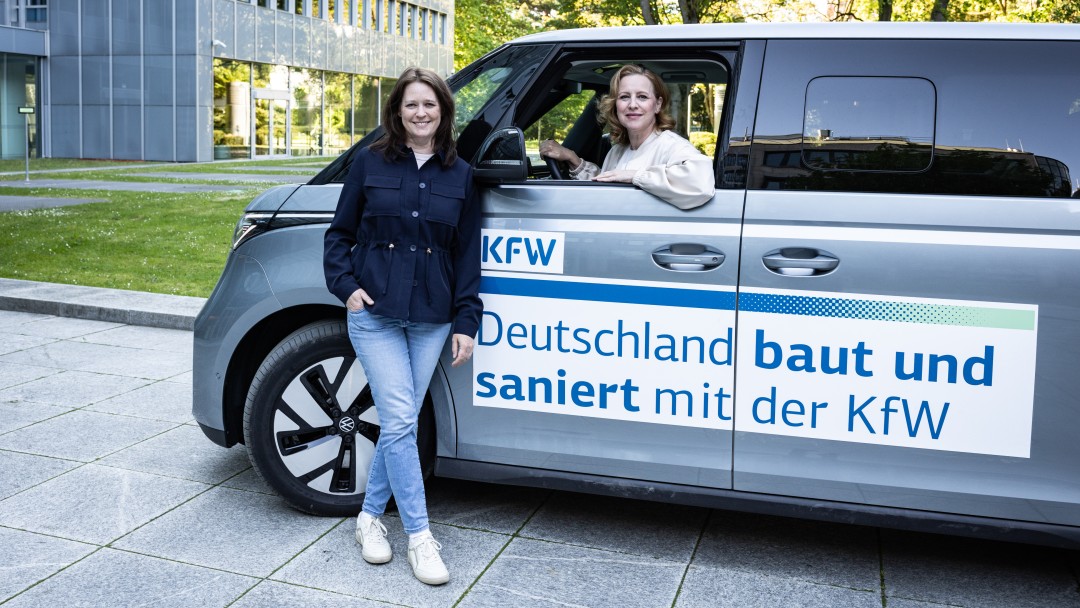 Eine KfW Mitarbeiterin am Steuer eines VW Busses 