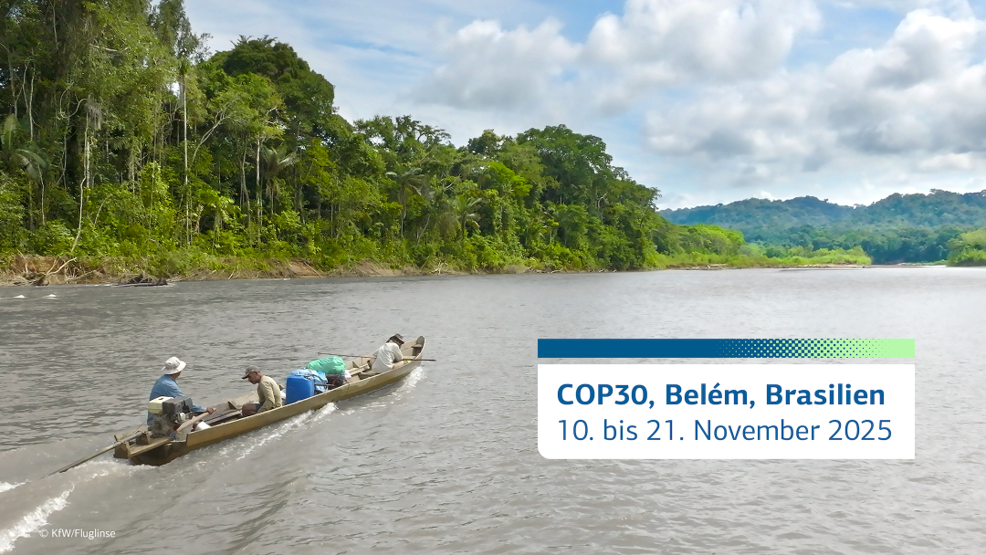 Drei Männer in einem kleinen Kanu auf einem Fluss neben dem Regenwald.