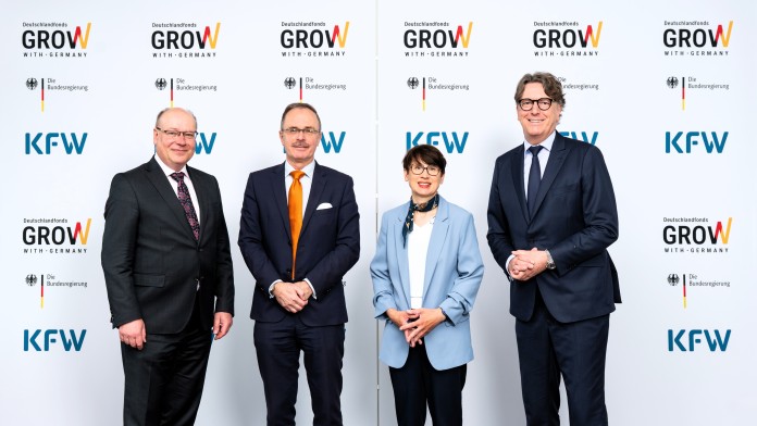 Vier Personen vor einer Pressewand