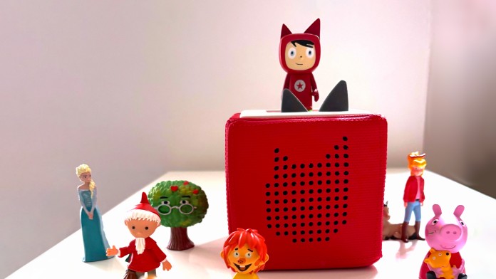Eine Toniebox und mehrere Tonie-Figuren stehen auf einem Tisch