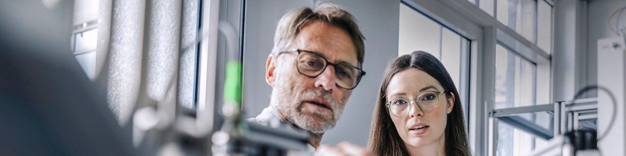 Junge Frau und Mann in einer Werkstatt oder einem Labor
