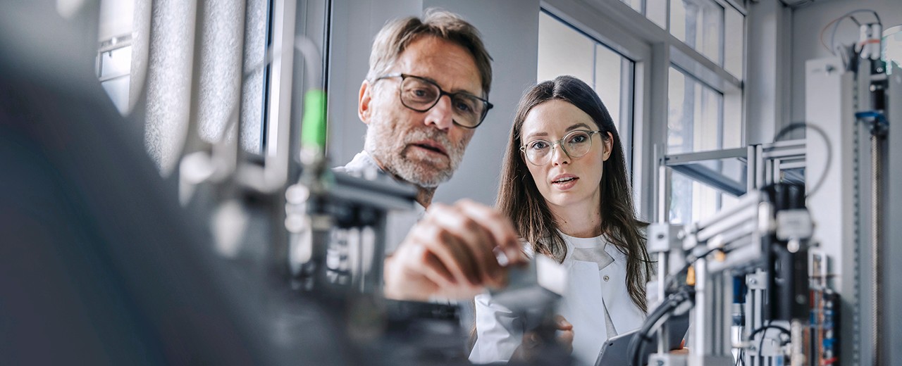 Junge Frau und Mann in einer Werkstatt oder einem Labor