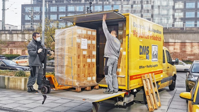 Mitarbeiter einer Spedition laden in Frankfurt Kisten mit den OP-Masken auf einen LKW.