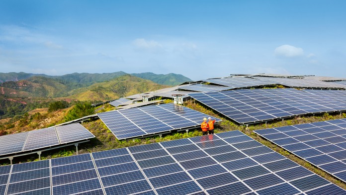 Zwei Arbeiter patrouillieren im Solarkraftwerk 